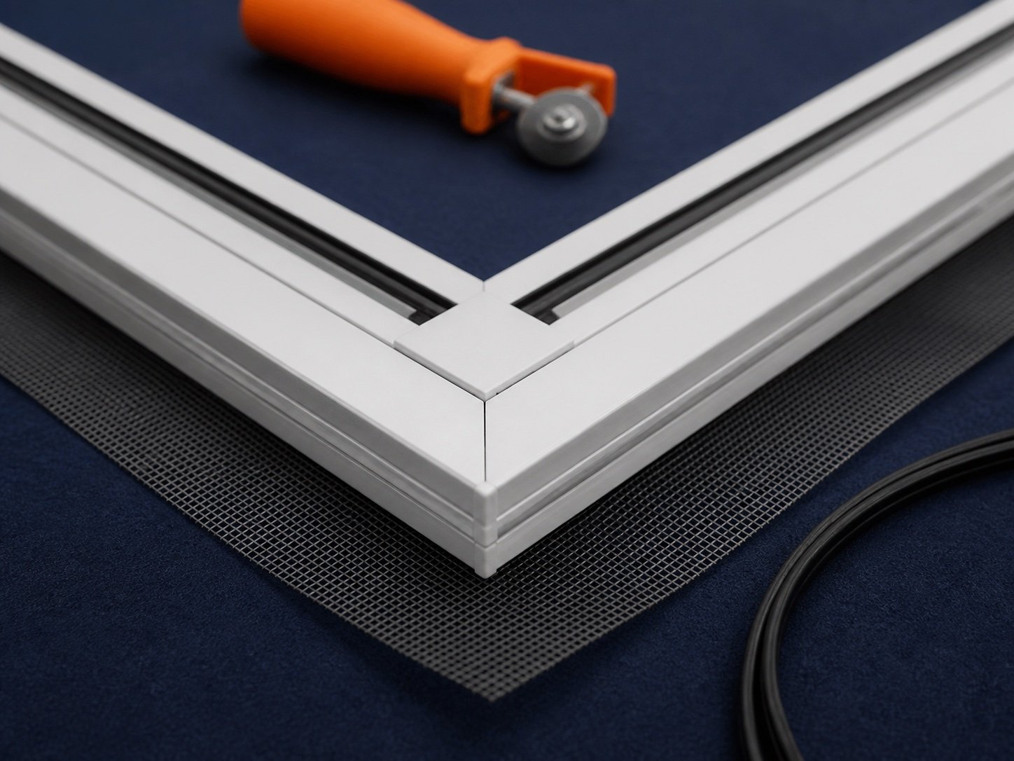 White screen-frame corner and spline prepared on a navy work mat