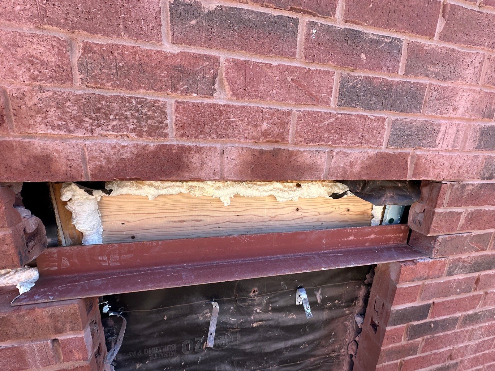 Steel lintel installed above a new opening in a brick wall