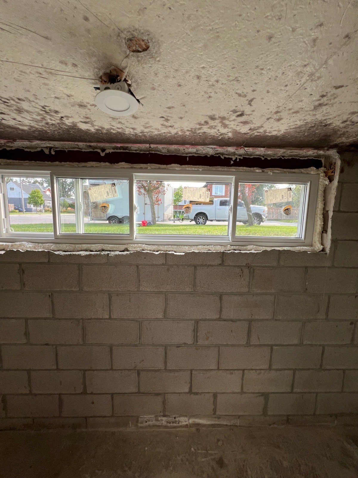 Long horizontal basement window assembly installed in a block wall
