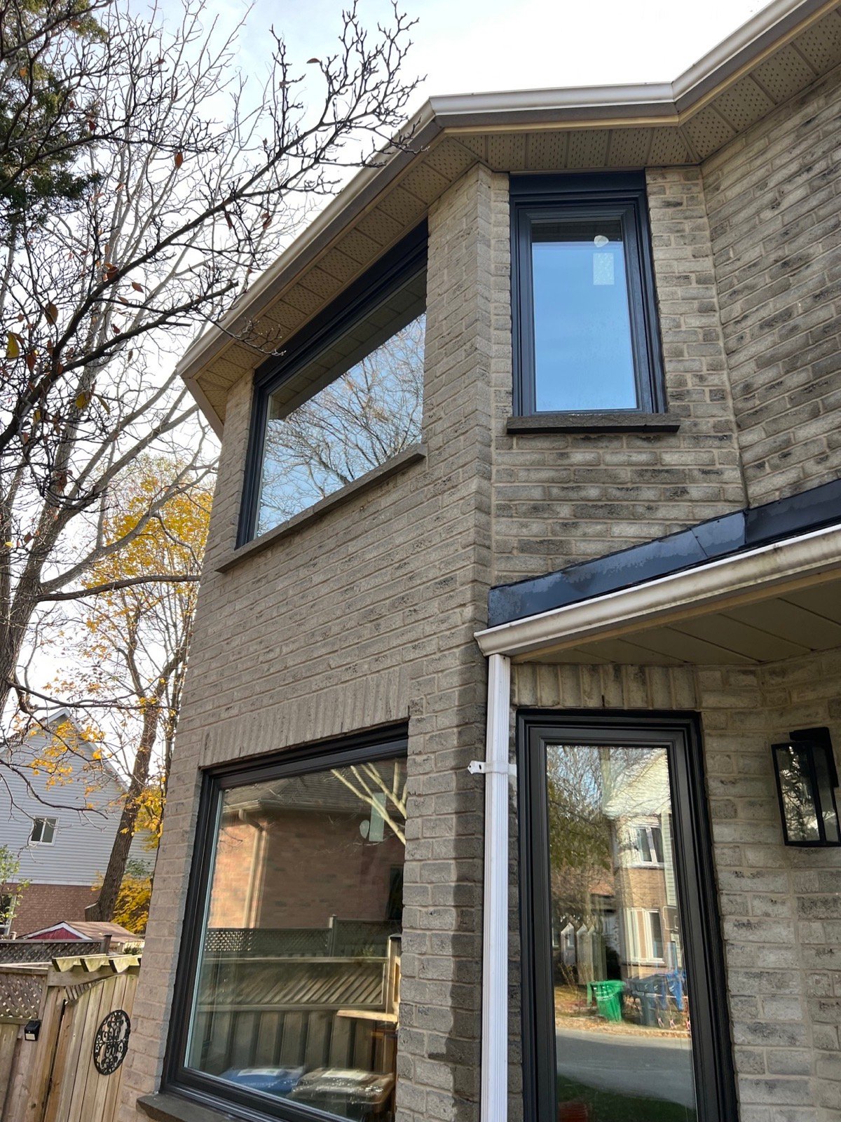 Tall arrangement of black-framed windows on a white-brick Mississauga home