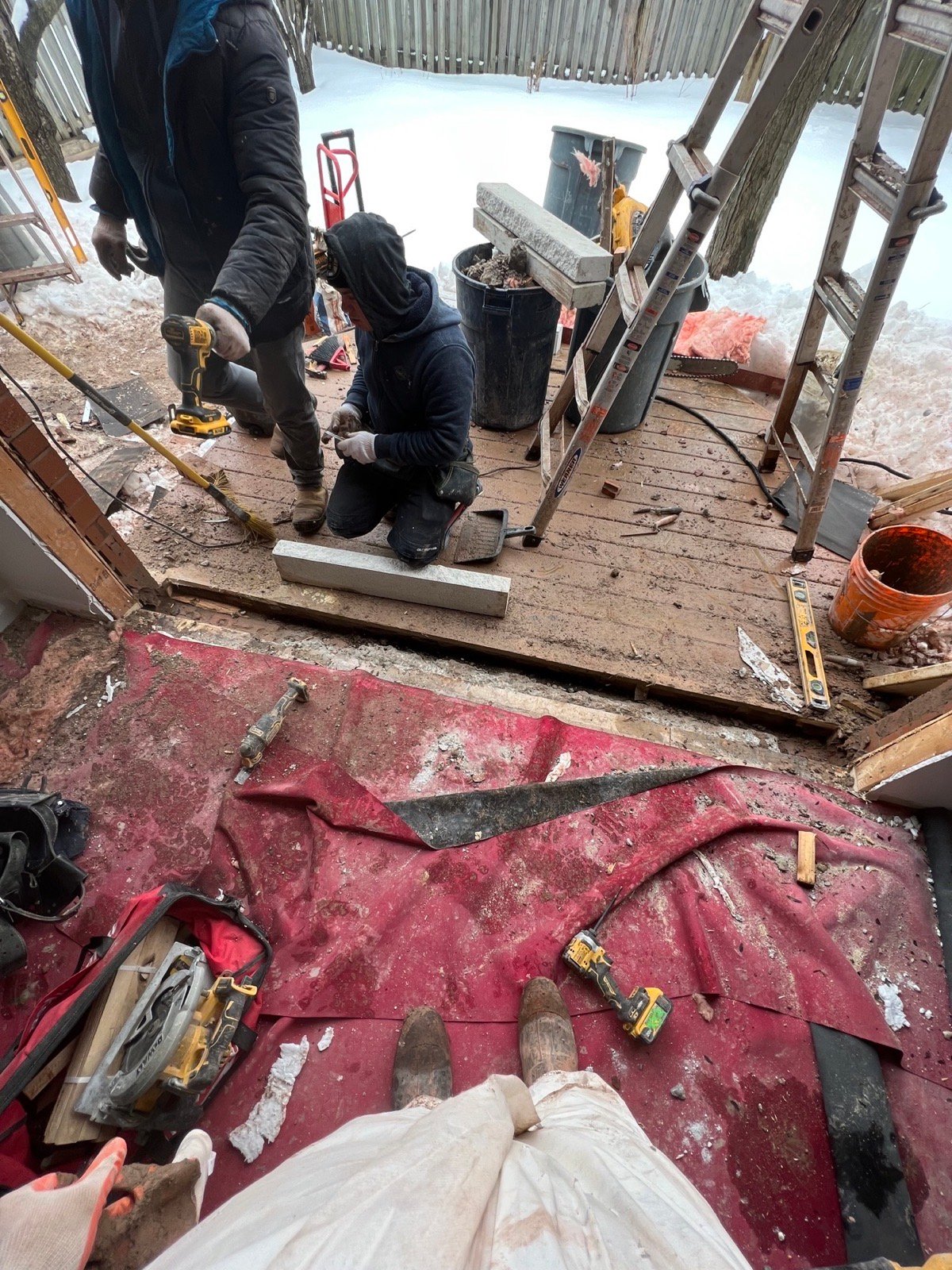 Installers preparing a wide rear wall opening for French doors